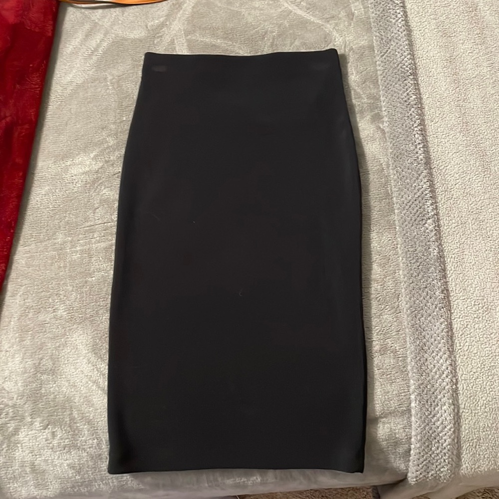 Black, polyester/spandex medium length pencil skirt. Never worn.
